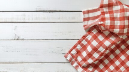 Obraz premium Bright, patterned kitchen towel laid across a white wooden table. Clean and minimalist, with plenty of space for product placement or text.