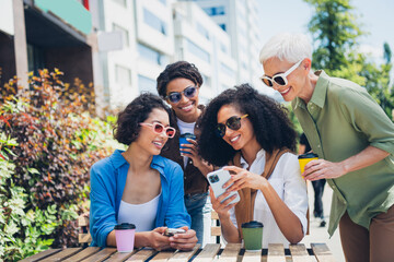 Photo of group friends women cafe table smart phone coffee weekend chill street cafe table outdoors