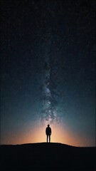 Fototapeta premium A starry night sky with a silhouette of a person gazin