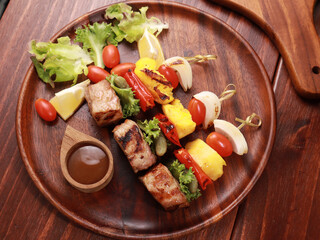 Barbecue grilled sliced ​​meat and vegetables on a wooden table