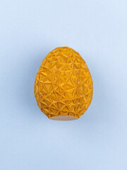 close-up volumetric colored egg with ornament on blue background