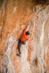 A rock climber ascends to the summit via a difficult route.