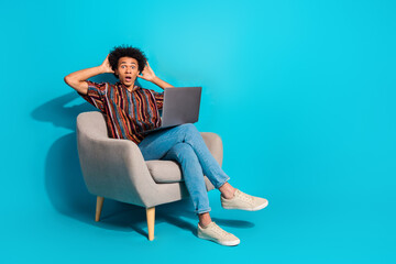 Full body portrait of nice young man sit chair use laptop empty space wear shirt isolated on turquoise color background