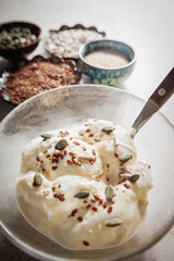 Seed cycling for hormonal balance - flax, pumpkin, sunflower and sesame seeds for different phases of menstrual cycle, women's health - a bowl of yogurt sprinkled with healthy seeds