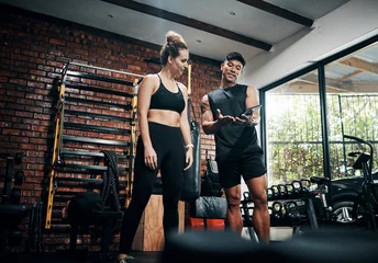 Fotobehang Persoonlijk Tablet, personal trainer and woman in gym, show and videos with demo, man and health with exercise. Talking, client and instructor in club, online and app for workout logging, fitness and info  © Frank Coop/peopleimages.com