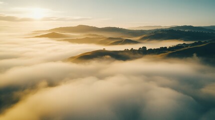 Fototapeta premium A serene aerial view of mist-covered hills bathed in warm sunlight, creating a tranquil landscape that evokes a sense of peace and beauty.