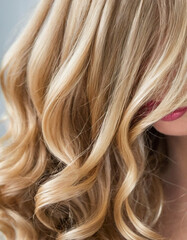 Obraz premium Soft, luminous curls frame the face, highlighting the vibrant and healthy texture of the blond hair. The close-up captures the intricate details beautifully. Care cosmetics. Generative AI