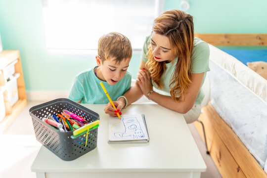 Mother and boy drawing sitting in the bedroom - Powered by Adobe