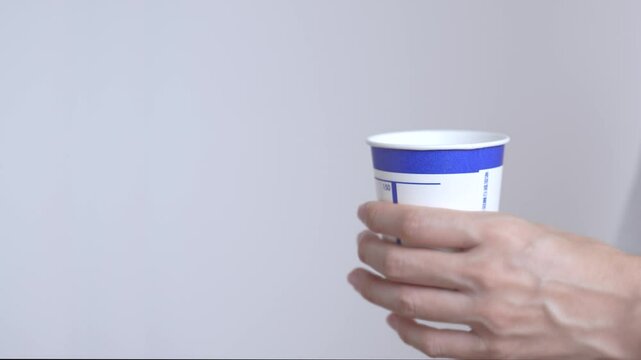 health check, hospital examinations, regular health check-ups, etc. Person holding a urine test cup.  健康診断、病院の検査、定期健診など。検尿カップを持つ人