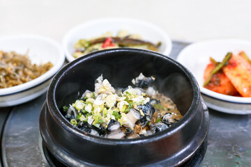 Hot Doenjang Stew Topped with Sliced Green Onions in a Stone Pot