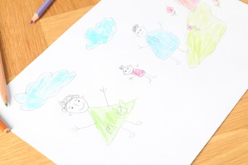 Child`s picture and pencils on wooden table, closeup