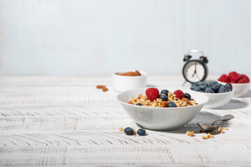 homemade granola with nuts and fresh berries on white table