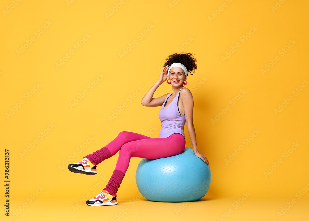 Wall mural Aerobics. Woman with fitness ball on orange background