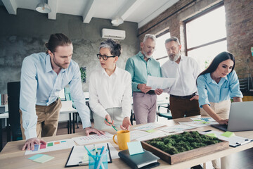 Photo of teamwork startup partners paperwork working process comfortable nice creative startup office loft room interior