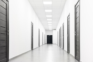 View of empty hospital corridor with wooden doors