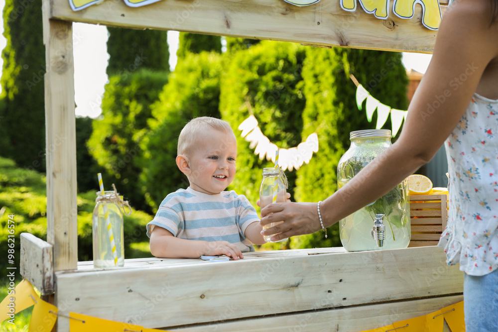 Canvas Prints Cute little boy selling natural lemonade to woman in park