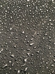 Water drops on black surface. Water droplets on dark background. Water droplets concept. Water drops on a black background. Banner with raindrops. Top view.