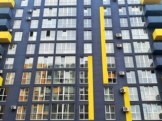 Fototapeta premium Architecture Background. Detail New high-rise Building or House Modern facade with windows. Contemporary geometrical architectural design backdrop. Real Estate concept. Yellow and Gray-Dark blue color