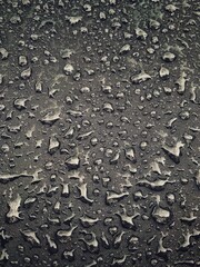 Water drops on black surface. Water droplets on dark background. Water droplets concept. Water drops on a black background. Banner with raindrops. Top view.