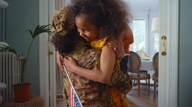 Cinematic video of a woman coming back home from the army military service in the us. Family reunited at lunch time indoor in a beautiful american house.