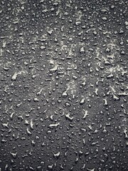 Water drops on black surface. Water droplets on dark background. Water droplets concept. Water drops on a black background. Banner with raindrops. Top view.