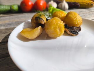 Golden baked potatoes on a white plate with rosemary.. High-quality photo