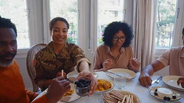 Cinematic video of a woman coming back home from the army military service in the us. Family reunited at lunch time indoor in a beautiful american house.