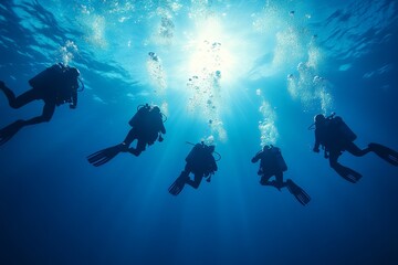 A group of divers exploring underwater depths with bubbles rising in sunlight at a tropical ocean destination