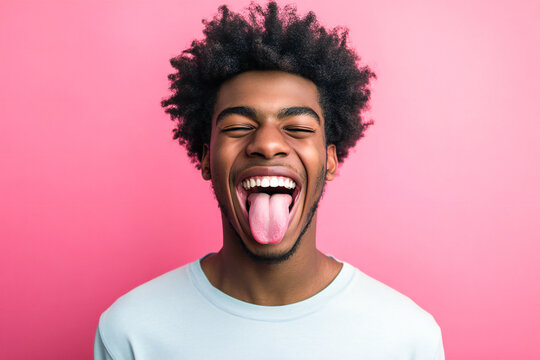 Portrait of a young black afro american man sticking his tongue