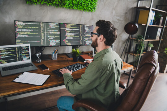 Portrait of professional hacker young man write keyboard computer desk loft interior office indoors