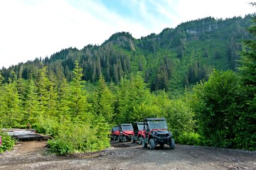 ATVs parked against a bright green forest and mountains © Camille Intson