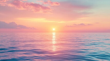 Warm pastel colors in the sky as the sun sets over a calm ocean