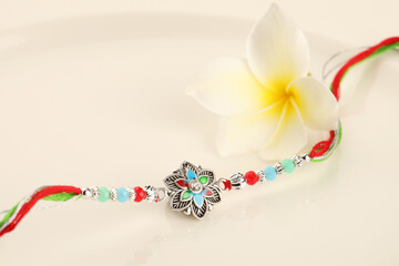 Raksha Bandhan, Indian festival with beautiful Rakhi, Rice Grains and flower. A traditional Indian wrist band which is a symbol of love between Sisters and Brothers