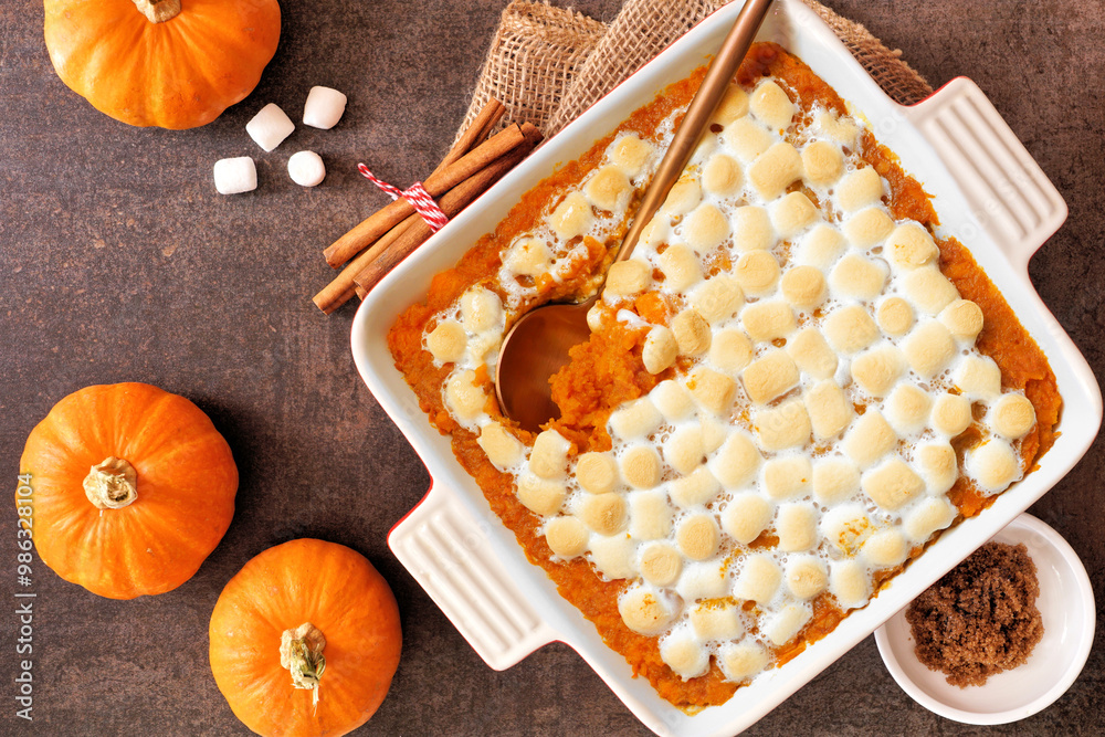Poster sweet potato casserole with toasted marshmallows. top down view table scene on a dark stone backgrou
