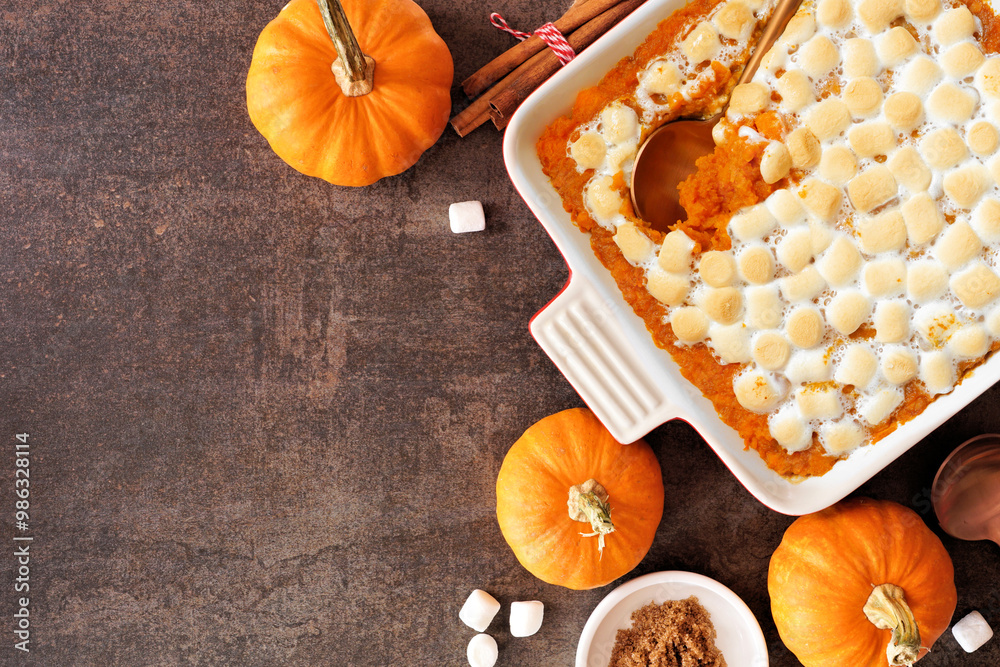 Poster sweet potato casserole with toasted marshmallows. above view table scene on a dark stone background 