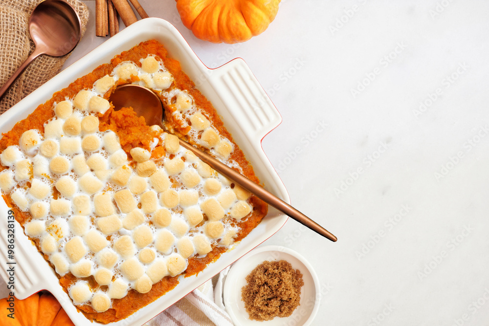 Poster sweet potato casserole with toasted marshmallows. top view table scene on a white marble background 