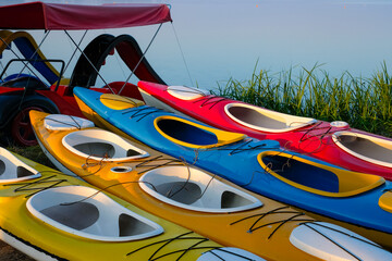 Colorful kayaks or canoes on a water background. Entertaining water transport. Active recreation...