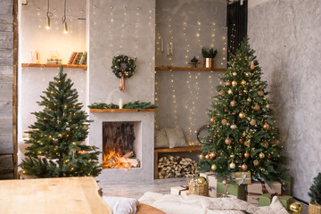 The interior of the Scandinavian-style living room, decorated for the Christmas holidays. Christmas tree next to the fireplace.
