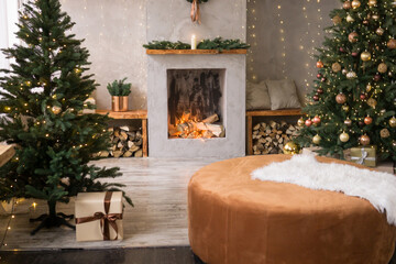 The interior of the Scandinavian-style living room, decorated for the Christmas holidays. Christmas tree next to the fireplace.
