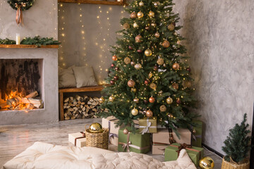 The interior of the Scandinavian-style living room, decorated for the Christmas holidays. Christmas tree next to the fireplace.
