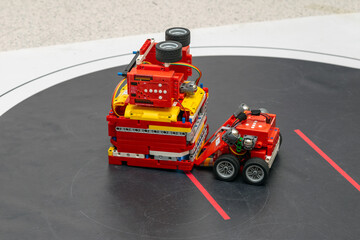 A small red robot against a big one in a sumo wrestling match
