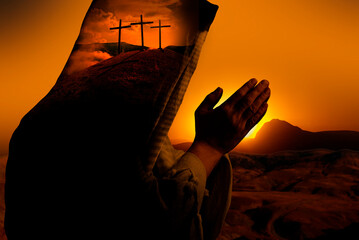A praying man and three wooden crosses on hill against sky. Biblical Crucifixion on Mount Golgotha,...