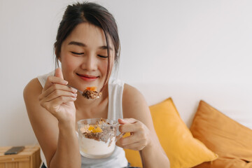 Asian woman proud to present a cup of homemade yogurt snack for healthy diet.