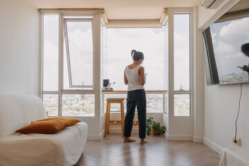 Asian woman walking around her room and chat with the mobile phone.