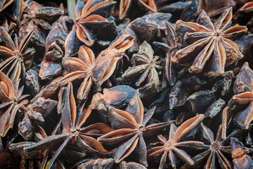 A close up of a bunch of dried up star anise. The spice is brown and has a strong aroma