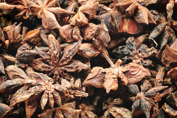 A close up of a bunch of dried up star anise. The spice is brown and has a strong aroma