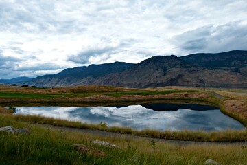 Fototapeta premium landscape with mountains and lake reflecting a cloudy sky