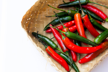 A picture of green chilies and red chilies in the ratan basket. Green chilies are high in vitamin C and beta-carotene, making them good for the skin. 