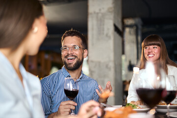 Happy business colleagues talking on a lunch in a restaurant.
