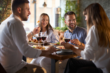 Happy business colleagues talking on a lunch in a restaurant.